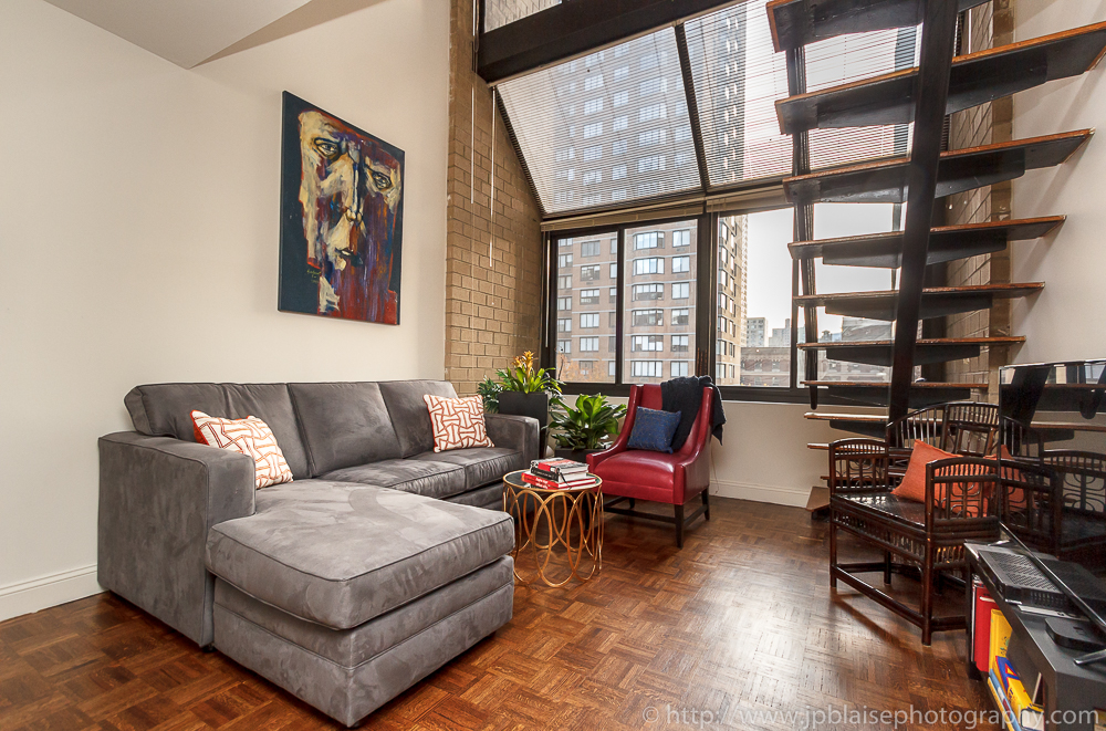 Real Estate photographer work, midtown apartment, view of the living room and the large window, new york city